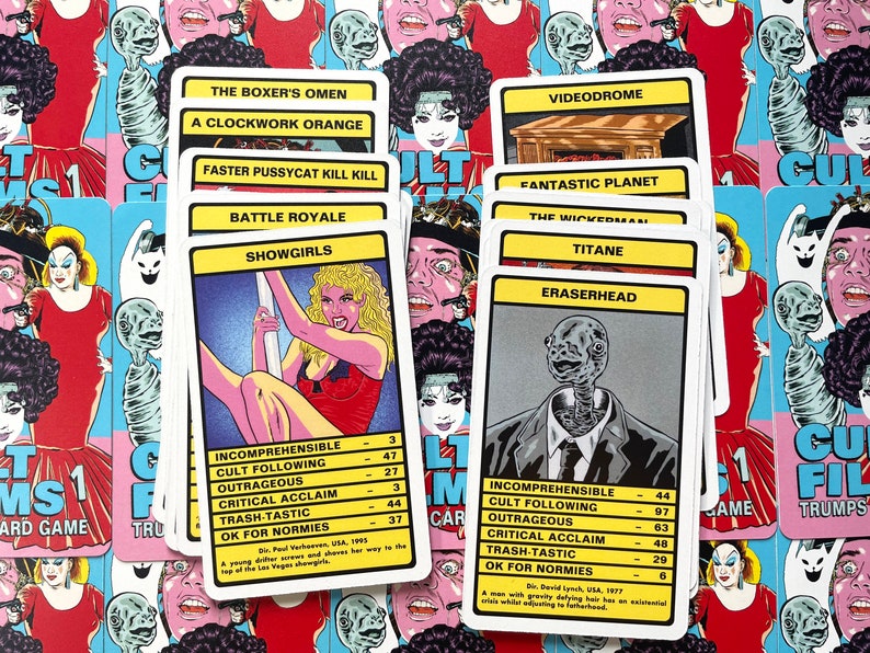 May include: A set of colourful playing cards featuring cult film titles and characters. The cards are arranged in a stack, with the top card showing "Showgirls" and the bottom card showing "Eraserhead".