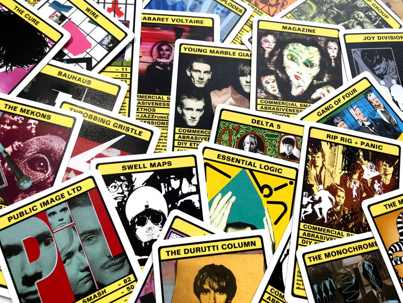 以下が含まれることがあります： The Cure、Bauhaus、Wire、Public Image Ltd. などのさまざまなバンドの名前が書かれたカードのコレクション。各カードは異なるデザインで、バンド名と短い説明が書かれています。