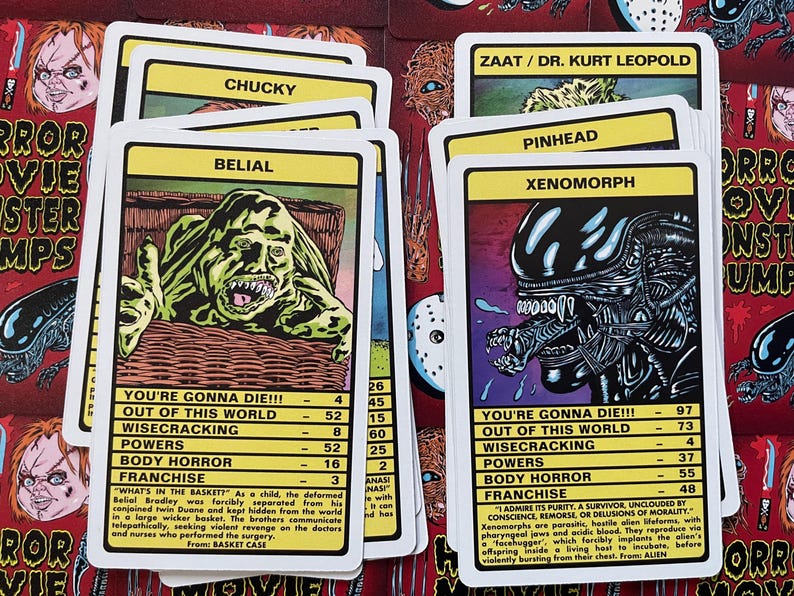 May include: A set of colourful trading cards featuring illustrations of horror movie monsters. Each card has a name, a statistic for "You're Gonna Die!!!", and a description of the monster's origin. The cards include characters like Chucky, Belial, Xenomorph, and Pinhead.