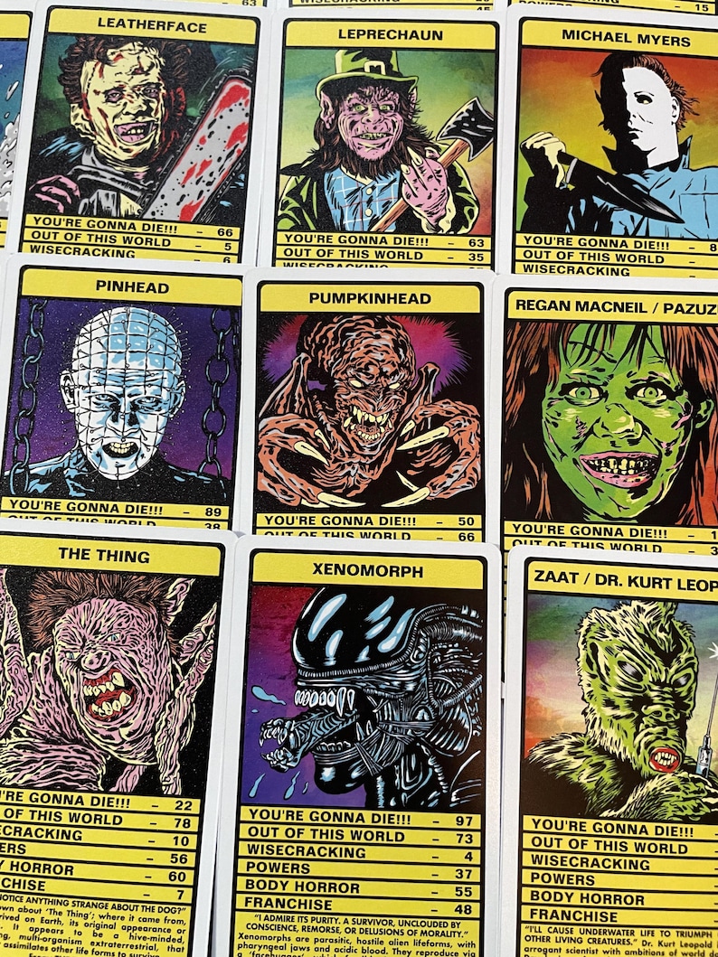 May include: A set of trading cards featuring illustrations of horror movie characters. Each card has a yellow background with black text and a colourful illustration of a character. The text on the cards includes the character's name, the movie they are from, and statistics about their powers and abilities. The characters include Leatherface, Leprechaun, Michael Myers, Pinhead, Pumpkinhead, Regan McNeil, The Thing, Xenomorph, and Zaat.