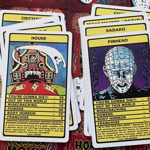 May include: A set of 10 horror movie trading cards featuring characters from popular films such as "House", "Hellraiser", "Critters", and "Sadako". Each card has a colourful illustration of the character and includes information about their powers, franchise, and how they die.