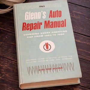 May include: A vintage "Glenn's Auto Repair Manual" book. The cover is light blue with red text, including the title and the years 1953 to 1965. The book covers American cars. The book is from Chilton Books.