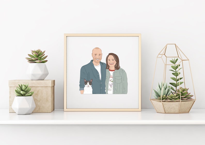 May include: A framed illustration of a couple and a cat. The couple is smiling, and the cat is black and white. The frame is gold, and the artwork is displayed on a white shelf with decorative plants.