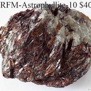 Op de afbeelding: Een ruw, natuurlijk astrofylliet mineraal specimen. De steen heeft een mix van donkerbruine, bronzen en zilverwitte kleuren met een kristallijne structuur. De tekst "RFM-Astrophyllite-10" is zichtbaar bovenaan.