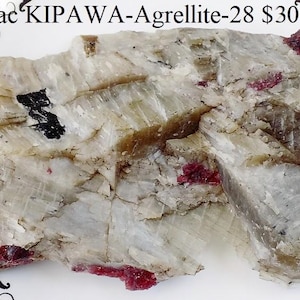 Op de afbeelding: Een grote, ruwe, witte en grijze steen met rode en zwarte mineraalinclusies. Lac KIPAWA-Agrellite-28 €300
