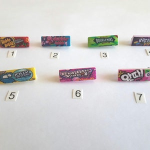 May include: Seven miniature packs of chewing gum, each with a different brand and flavor. The brands are Hubba Bubba, Double Bubble, Doublemint, Razzles, Jolly Rancher, Bubble Yum, and Big Ouch!