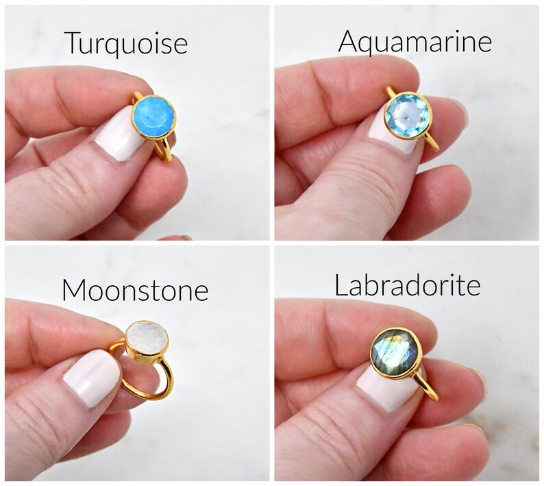 May include: Four gold-colored rings with different gemstones: turquoise, aquamarine, moonstone, and labradorite. Each ring features a round gemstone set in a simple gold band. The text "Turquoise", "Aquamarine", "Moonstone", and "Labradorite" is displayed above each ring.