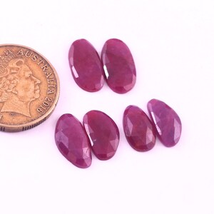 Puede incluir: Seis piedras preciosas de rubí de forma ovalada y facetadas en varios tonos de rosa. Las piedras preciosas están dispuestas en dos filas de tres.