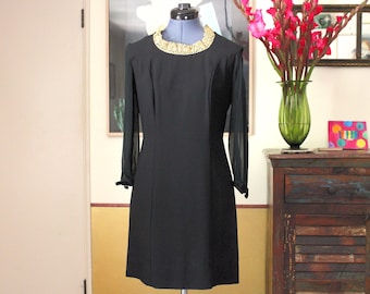 Vestido de cóctel de gabardina negra de los años 50: cuello de encaje dorado y mangas transparentes.