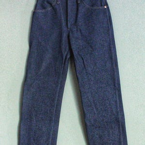 Puede incluir: Un par de pantalones vaqueros de mezclilla azul oscuro con un corte recto cl&aacute;sico. Los pantalones tienen cierre de bot&oacute;n y trabillas para cintur&oacute;n.