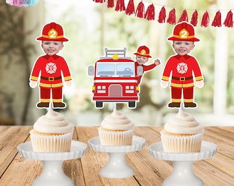 May include: Three red and white cupcake toppers featuring a fire engine and a firefighter. The firefighter is wearing a red helmet with the number 2 on it. The cupcake toppers are on white cupcake stands.