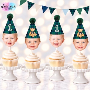 Puede incluir: Cuatro adornos para cupcakes con una cara de beb&eacute; sonriente que lleva un gorro de fiesta a cuadros verdes y azules con un pomp&oacute;n verde oscuro. Dos gorros muestran el n&uacute;mero 1 y dos tienen una peque&ntilde;a ilustraci&oacute;n de un oso de peluche marr&oacute;n.