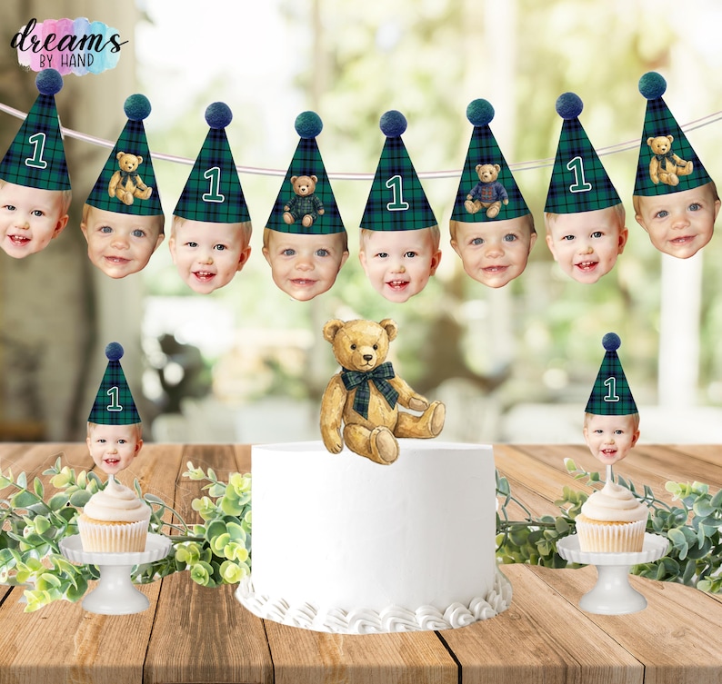 Puede incluir: Un set de decoraci&oacute;n de fiesta con una guirnalda de caras de beb&eacute; con gorros de fiesta de cuadros verdes y el n&uacute;mero 1, un adorno de oso de peluche para tarta y dos adornos para cupcakes con caras de beb&eacute; y el logo Dreams by Hand.