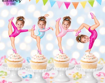 Puede incluir: Cuatro adornos para cupcakes con la cara de un niño en un cuerpo de gimnasta en varias poses. Las gimnastas visten leotardos rosas, azules y rosa claro. Cada adorno está montado en un palillo y colocado en un cupcake. Texto "dreams BY HAND".