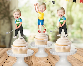 Könnte beinhalten: Drei weiße Cupcakes mit weißem Frosting, die mit einem Golfer-Cupcake-Topper verziert sind. Die Topper zeigen einen Cartoon-Jungen in Golfkleidung, der einen Golfschläger hält. Die Cupcakes stehen auf weißen Kuchenständern.