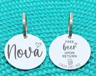 May include: Two silver dog tags with a key ring. One tag says "Nova" with a heart symbol. The other tag says "Free beer upon return" with a beer mug icon and the phone number 0424 240 183.