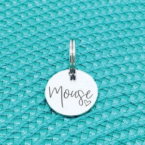 May include: Silver round pet tag with the name "Mouse" engraved in cursive script and a small heart symbol.