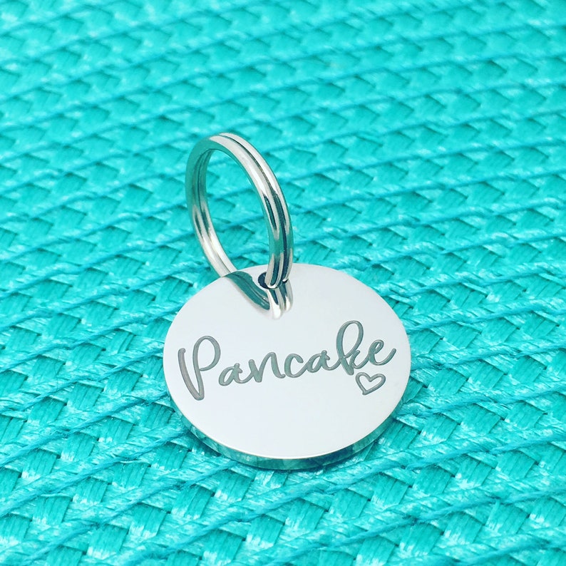 May include: Silver key chain with a round tag that says "Pancake" with a small heart symbol.