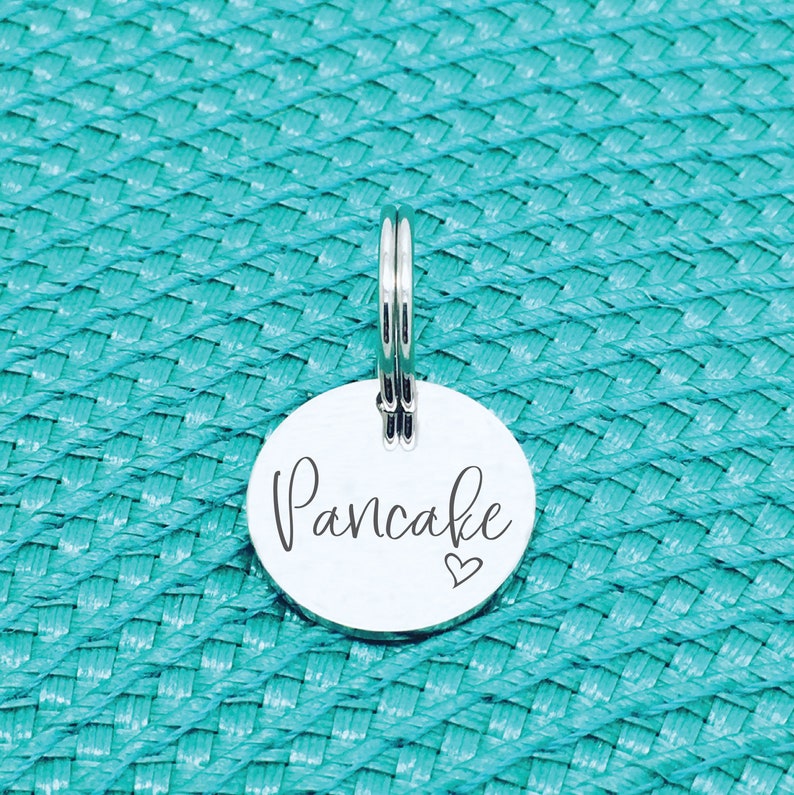 May include: Silver key chain tag with the word "Pancake" and a small heart engraved on it.