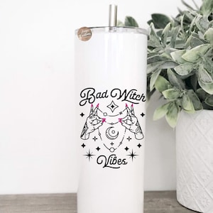 May include: White stainless steel tumbler with a black and white graphic of two hands holding a crescent moon and stars. The text "Bad Witch Vibes" is printed on the tumbler.