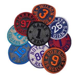 May include: Nine embroidered patches with different team names and numbers. The patches are in various colors, including black, white, red, blue, orange, and gray. The patches are circular and have a stitched border.