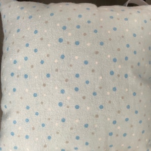 May include: A light blue pillow with a white and blue polka dot pattern.