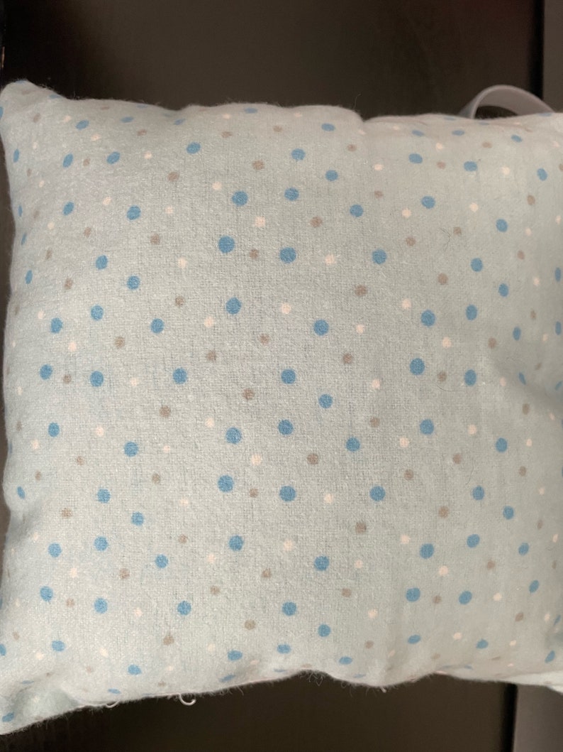 May include: A light blue pillow with a white and blue polka dot pattern.