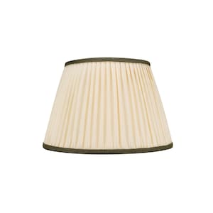 May include: Cream-coloured pleated lampshade with a dark green trim. The lampshade has a classic, tapered shape and is designed to diffuse light. The pleats create a textured surface, adding visual interest. Suitable for various home decor styles.