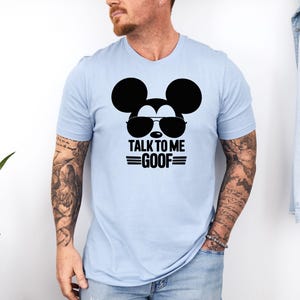 Puede incluir: Camiseta azul claro con un gr&aacute;fico negro de Mickey Mouse con gafas de sol y el texto "TALK TO ME GOOF". La camiseta de manga corta est&aacute; hecha de un material suave.