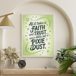 May include: A framed print with the text "All it takes is Faith and Trust... and a little bit of Pixie Dust." The print has a light green background with star accents. The print is displayed on a wooden shelf with a clock, vase, and greenery.