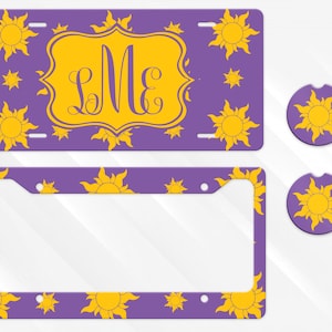May include: Purple license plate, license plate frame, and car coasters featuring a yellow sun design. The license plate has a yellow monogram in a decorative frame. The license plate frame and coasters have a repeating sun pattern.