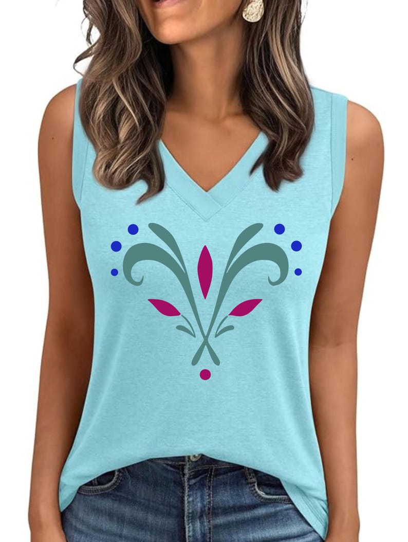 May include: A light blue sleeveless top with a V-neck. The shirt features a floral design in teal, pink, and blue. The floral design is centered on the front of the shirt. The top is made of a soft material.