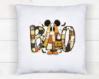 May include: White square pillow with a Halloween-themed design. The design features the word "BOO" in patchwork style, with a ghost character holding a jack-o'-lantern. The ghost has Mickey Mouse ears. Bats and stars are also included in the design.