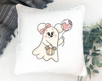 May include: White square pillow featuring a cartoon ghost character with a pink bow, holding a pumpkin-shaped basket and a pink Mickey Mouse balloon. The ghost has a friendly expression. The pillow is a Halloween-themed decorative item.