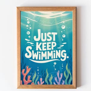 May include: A framed art print with an underwater scene. The print features the words "JUST KEEP SWIMMING" in white, with a blue background, bubbles, and coral. The frame is made of wood.
