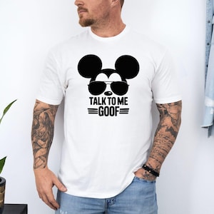 Puede incluir: Camiseta blanca con un gr&aacute;fico negro de Mickey Mouse con gafas de sol y el texto "TALK TO ME GOOF". La camiseta es de cuello redondo.