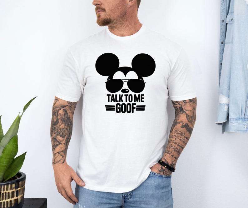 Puede incluir: Camiseta blanca con un gr&aacute;fico negro de Mickey Mouse con gafas de sol y el texto "TALK TO ME GOOF". La camiseta es de cuello redondo.