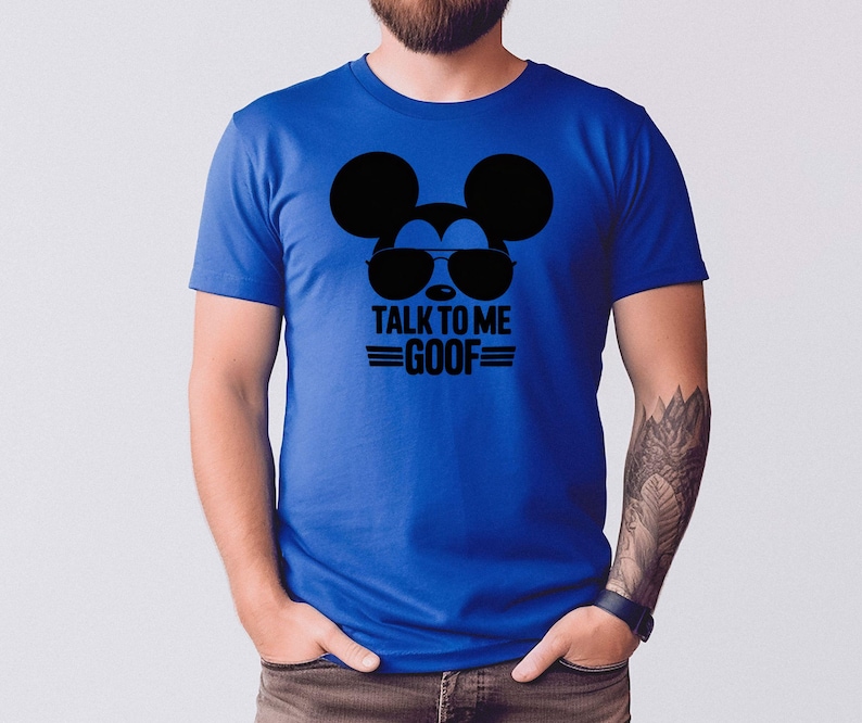 Puede incluir: Camiseta azul real con un gr&aacute;fico negro de Mickey Mouse con gafas de sol y el texto "TALK TO ME GOOF". La camiseta de manga corta est&aacute; hecha de un material suave.