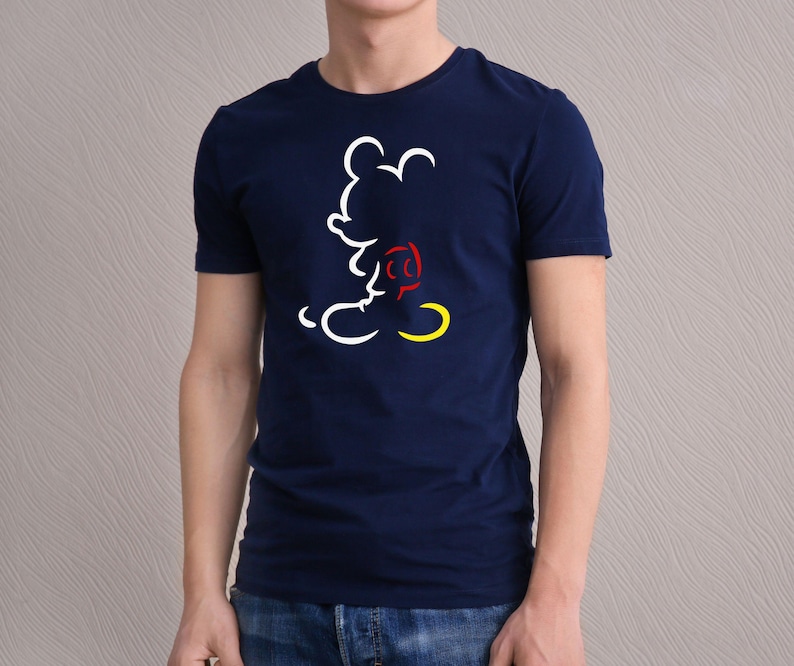 May include: Navy blue t-shirt featuring a white, red, and yellow outline of a cartoon mouse. The design is a minimalist illustration of the character. The shirt is a classic crew neck style.