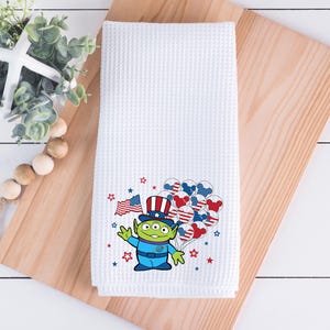 May include: A trio of cream-glazed ceramic mugs, each adorned with a hand-painted floral pattern in blue, green, and yellow hues. The mugs have a rounded form and a handle, ideal for enjoying a warm beverage.