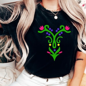 May include: Black t-shirt with a green, pink, and purple floral design. The design features a stylized flower with a stem and leaves.