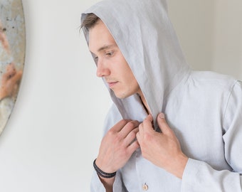 May include: A light gray hooded shirt with a button-up front and long sleeves. The shirt is made of a soft, lightweight fabric.