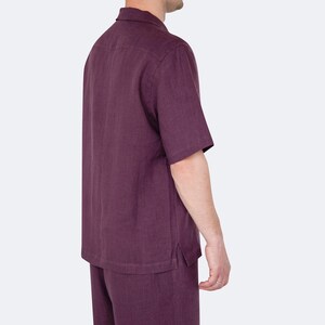 Model wearing mens eggplant color linen shirt and shorts set, side view