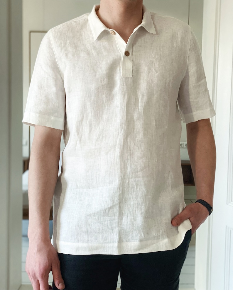 White linen polo shirt with short sleeves, wooden buttons, ribbed cuffs, and a regular fit