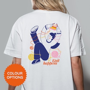 May include: White t-shirt with a colorful illustration of a person knitting, surrounded by yarn balls and threads. The text "Knit happens" is below the illustration. An orange "COLOUR OPTIONS" button is at the bottom.