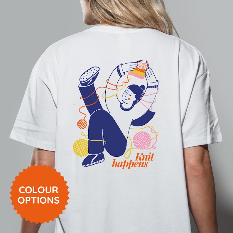 May include: White t-shirt with a colorful illustration of a person knitting, surrounded by yarn balls and threads. The text "Knit happens" is below the illustration. An orange "COLOUR OPTIONS" button is at the bottom.