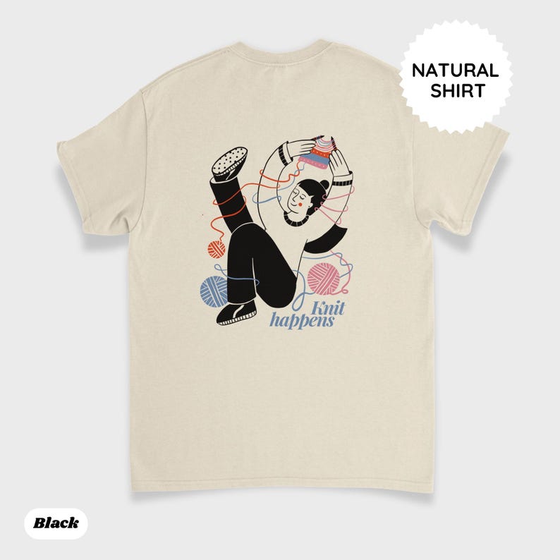 May include: Cream-colored t-shirt with a graphic of a person knitting, surrounded by yarn balls. The text "Knit happens" is below the illustration. A circular tag on the upper right reads "NATURAL SHIRT". The word "Black" is at the bottom left.