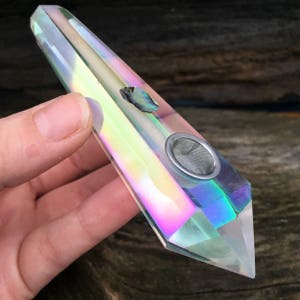 May include: A clear iridescent crystal pipe with a metal screen and a small abalone shell inlay.
