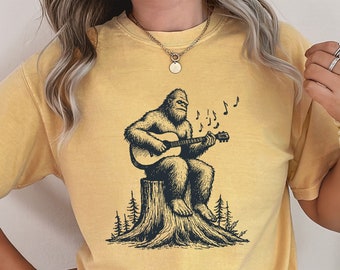Koszulka Comfort Colors Bigfoot Playing Guitar, koszulka Cryptozoology, koszulka Sasquatch, prezent na dzień ojca, zabawna fajna koszulka