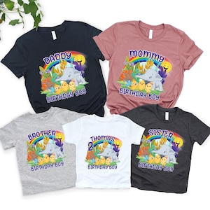 May include: Set of six t-shirts featuring a rainbow, a sun, and an elephant with the text "Daddy of the Birthday Boy", "Mommy of the Birthday Boy", "Brother of the Birthday Boy", "Thomas 2 Birthday Boy", "Sister of the Birthday Boy", and "[Name] Birthday Boy".